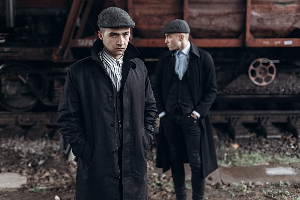Period-dressed gangsters by a railway carriage