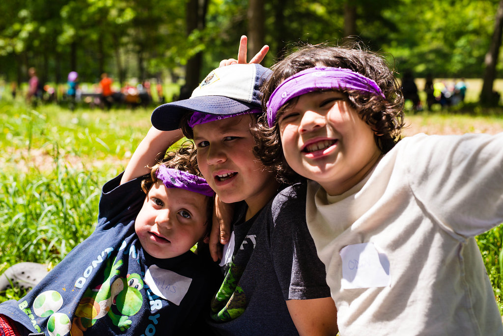 Three campers smiling together outdoors